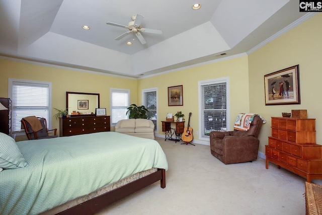 carpeted bedroom featuring ornamental molding, multiple windows, ceiling fan, and a raised ceiling