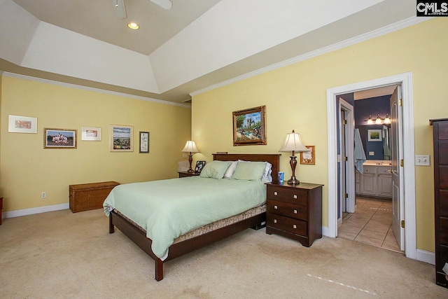 carpeted bedroom with ornamental molding, ceiling fan, a tray ceiling, and connected bathroom