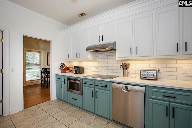 kitchen featuring white cabinets, light tile patterned flooring, appliances with stainless steel finishes, and crown molding