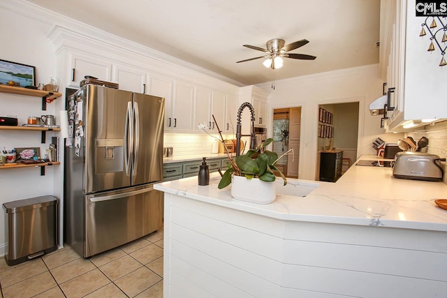 kitchen with decorative backsplash, kitchen peninsula, white cabinets, stainless steel refrigerator with ice dispenser, and light tile patterned floors