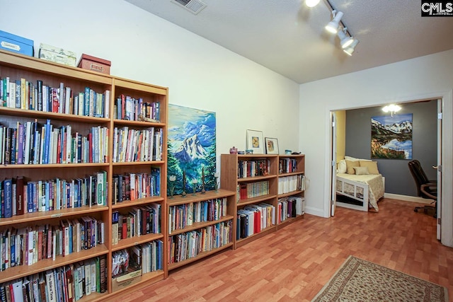 living area with hardwood / wood-style flooring and rail lighting