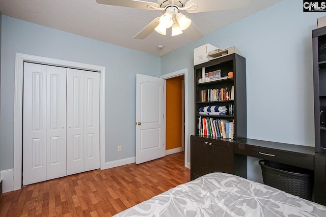 bedroom featuring hardwood / wood-style flooring, ceiling fan, a closet, and a textured ceiling