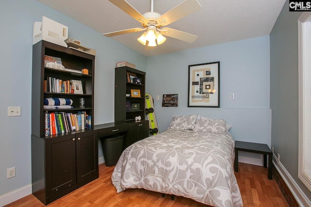 bedroom with ceiling fan, a textured ceiling, and light hardwood / wood-style flooring