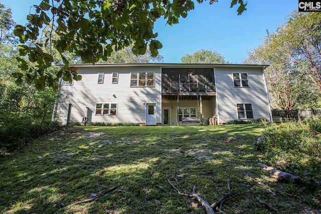 rear view of property with a sunroom and a lawn