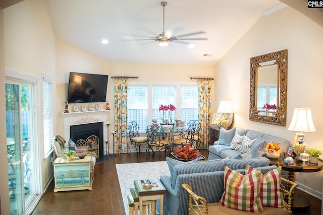 living room featuring a healthy amount of sunlight, ceiling fan, vaulted ceiling, and dark hardwood / wood-style flooring