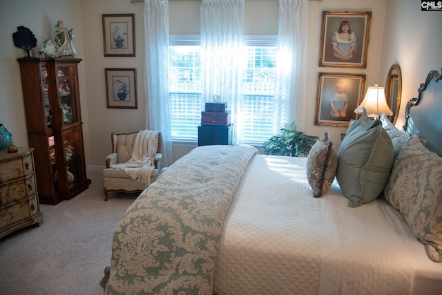 bedroom featuring light colored carpet and multiple windows