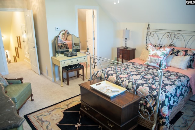 bedroom featuring lofted ceiling and light carpet