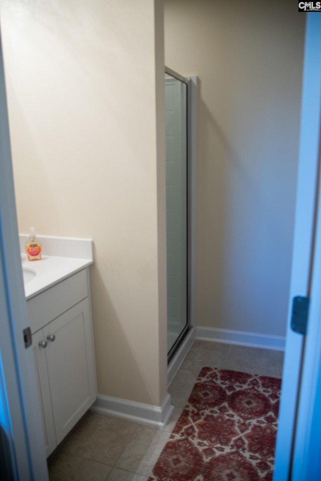 bathroom featuring tile patterned floors, an enclosed shower, and vanity