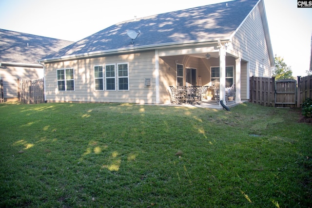 back of property with a patio, a yard, and ceiling fan