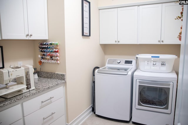 laundry room with washing machine and clothes dryer and cabinets