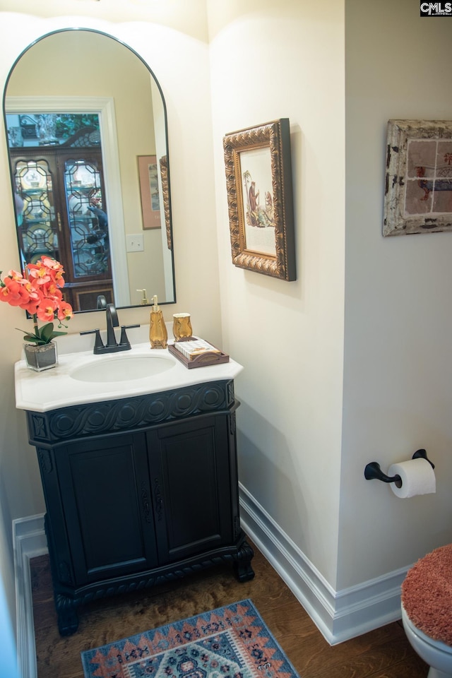 bathroom with hardwood / wood-style flooring, vanity, and toilet