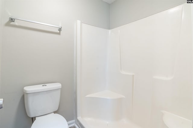 bathroom featuring walk in shower and toilet