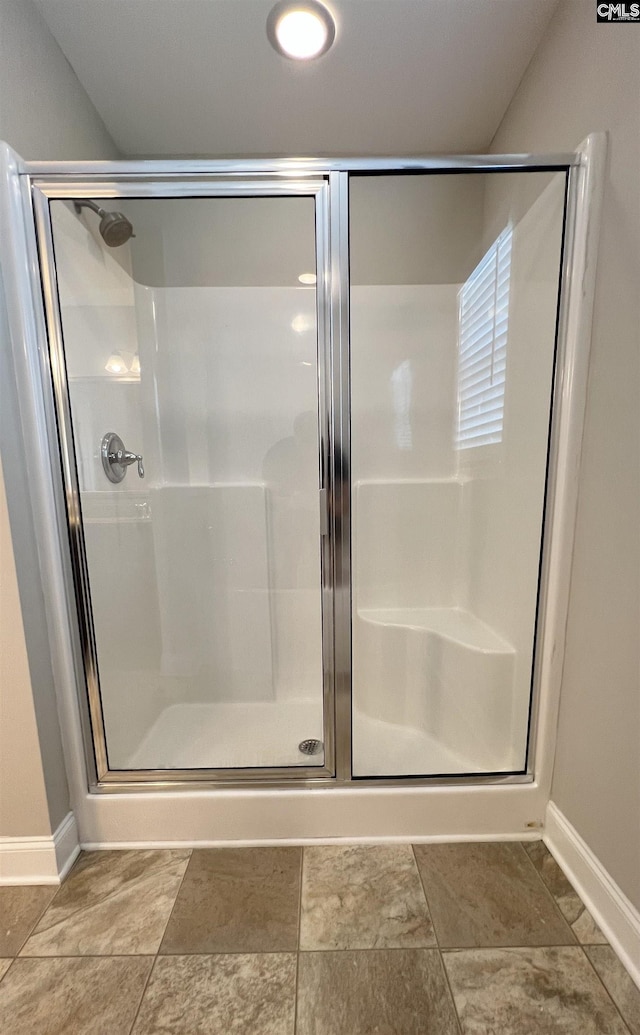 bathroom with a shower with door