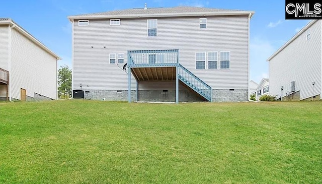 rear view of property featuring a yard and a deck