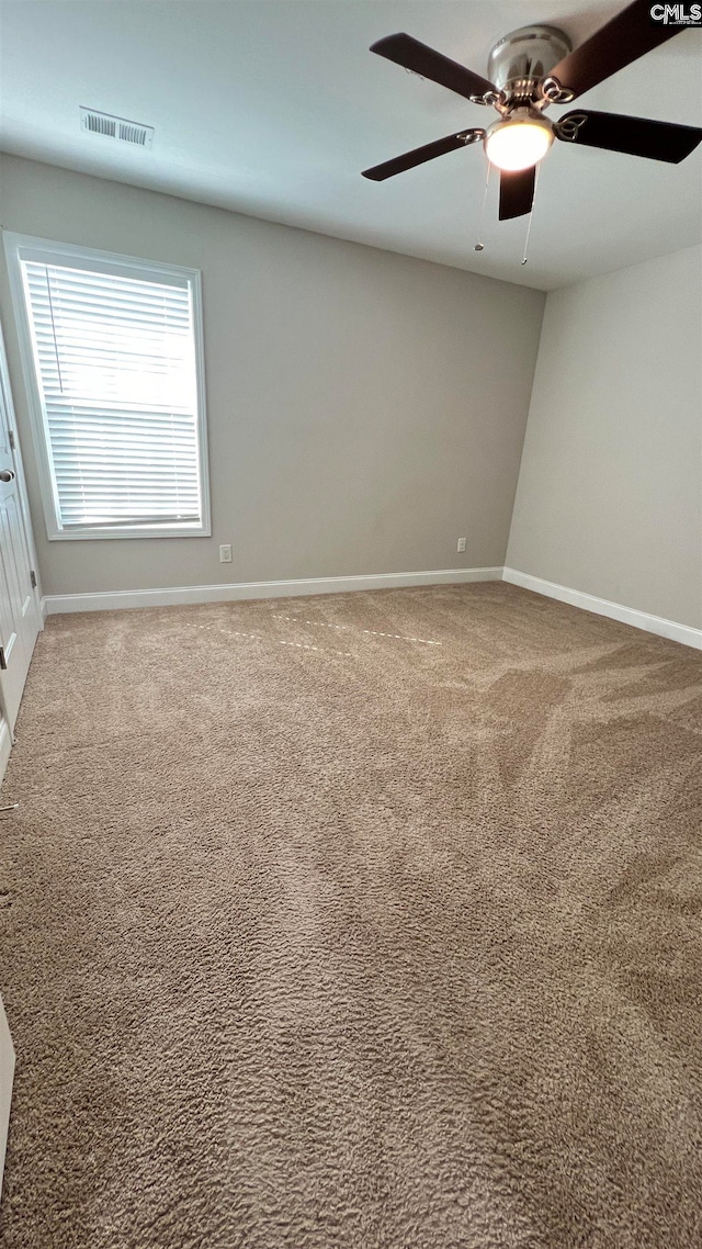 carpeted spare room with ceiling fan