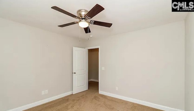 carpeted spare room with ceiling fan