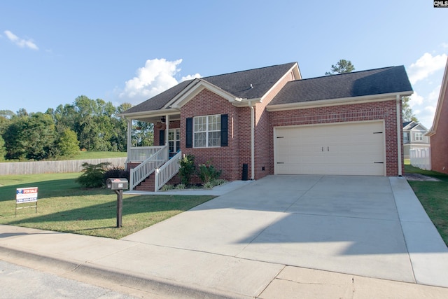 view of front facade with a front yard, covered porch, and a garage