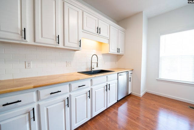 kitchen featuring dishwasher, sink, dark hardwood / wood-style flooring, white cabinets, and decorative backsplash