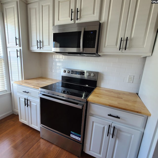 kitchen featuring white cabinets, appliances with stainless steel finishes, dark hardwood / wood-style floors, and wooden counters