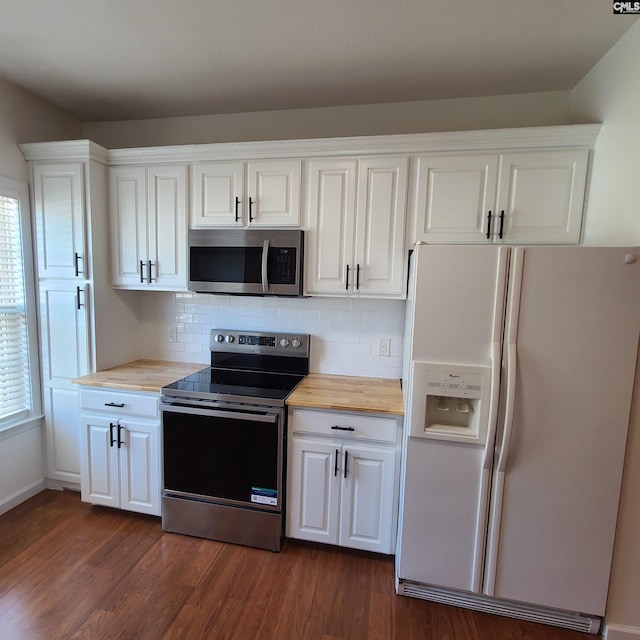 kitchen featuring dark wood-type flooring, stainless steel appliances, white cabinets, butcher block countertops, and tasteful backsplash