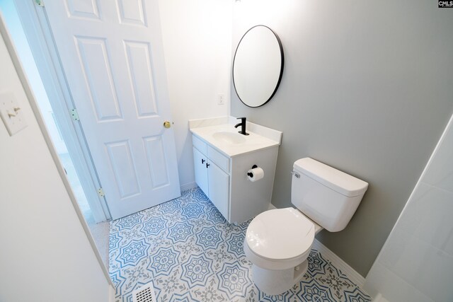 bathroom with vanity, toilet, and tile patterned flooring