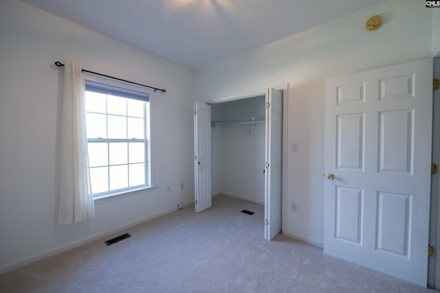 unfurnished bedroom featuring light colored carpet and a closet