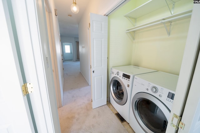 clothes washing area featuring washing machine and clothes dryer and light colored carpet