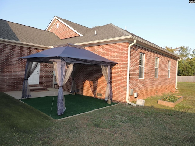 back of property featuring a patio, a gazebo, and a yard