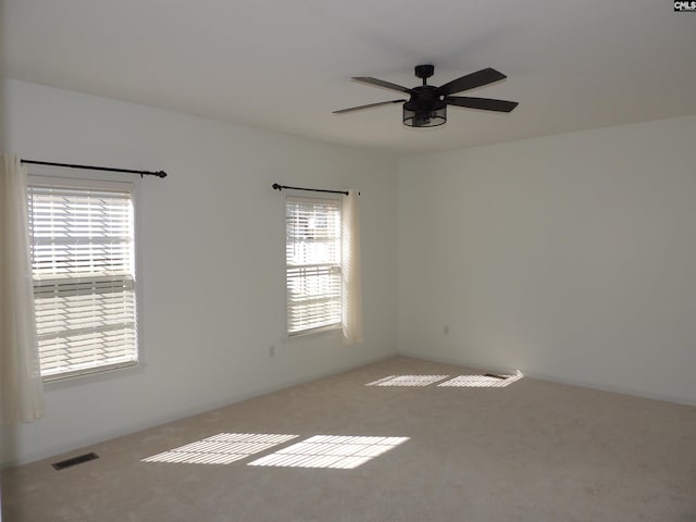 unfurnished room featuring carpet, ceiling fan, and plenty of natural light