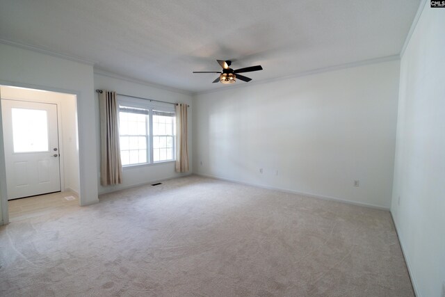 carpeted spare room featuring ceiling fan and crown molding