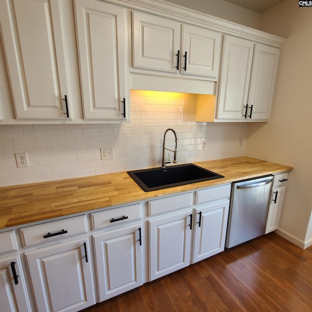 kitchen featuring stainless steel dishwasher, sink, white cabinetry, and wooden counters