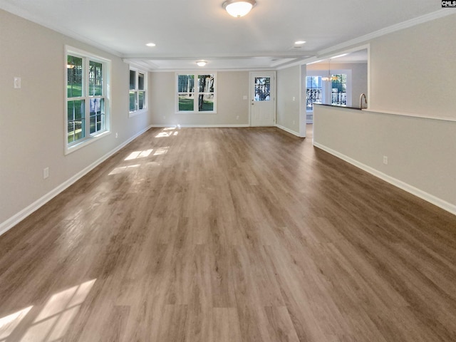 unfurnished living room featuring ornamental molding, a chandelier, and wood-type flooring