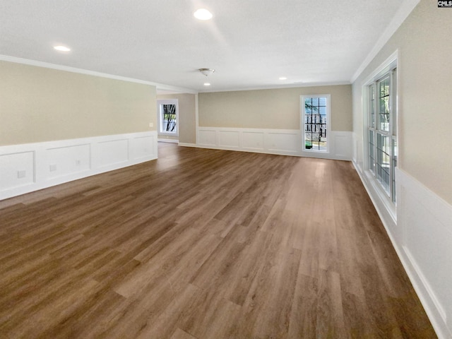 unfurnished living room featuring crown molding, a textured ceiling, and dark hardwood / wood-style floors