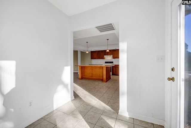 kitchen featuring tasteful backsplash, hanging light fixtures, and light tile patterned floors