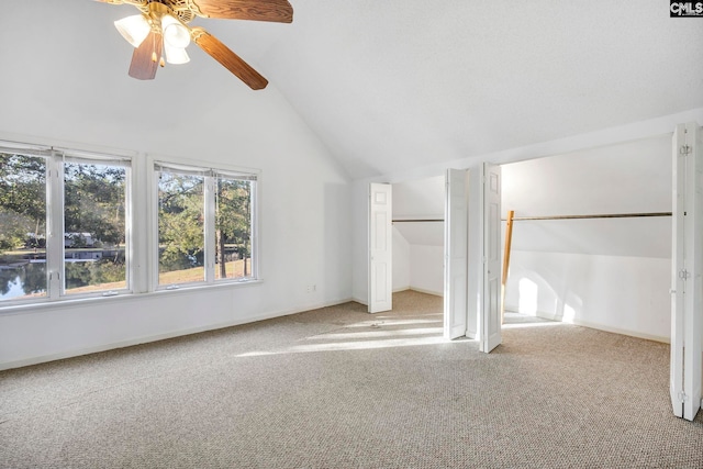 unfurnished bedroom with ceiling fan, carpet, and vaulted ceiling