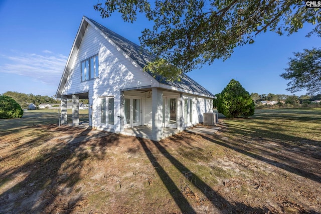 view of side of home with central AC, a patio area, and a lawn