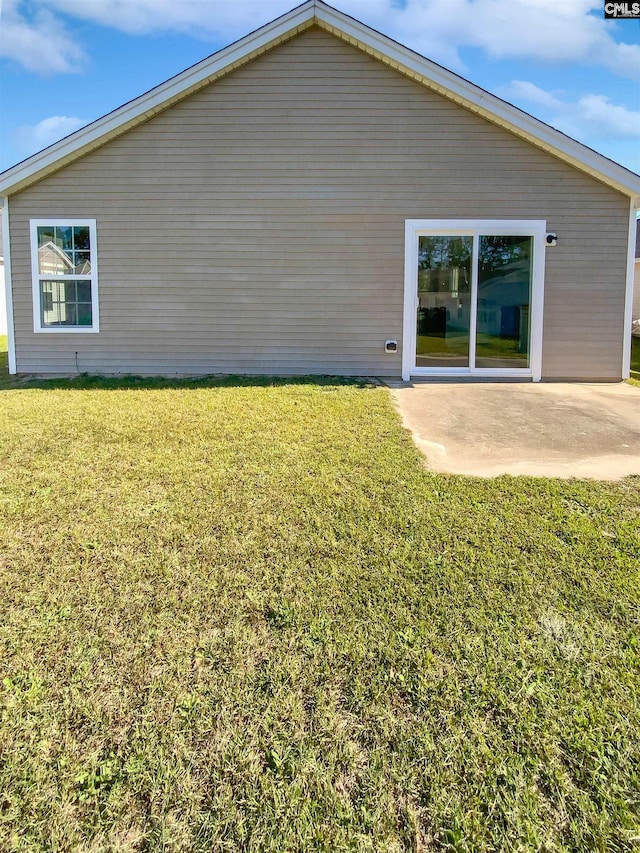 back of property featuring a yard and a patio