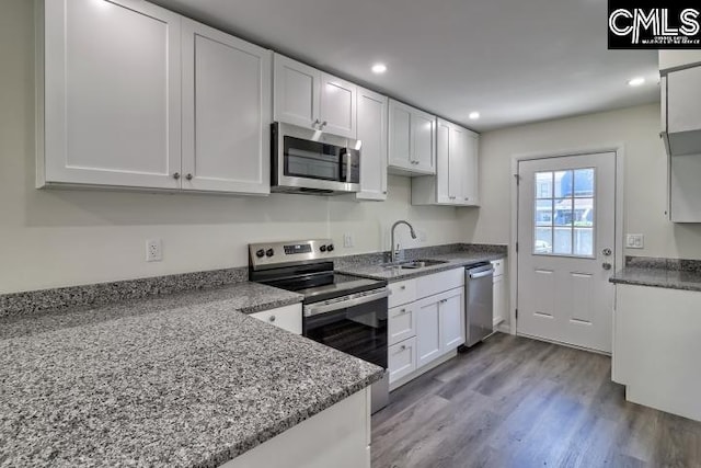 kitchen featuring light hardwood / wood-style flooring, appliances with stainless steel finishes, sink, and white cabinets