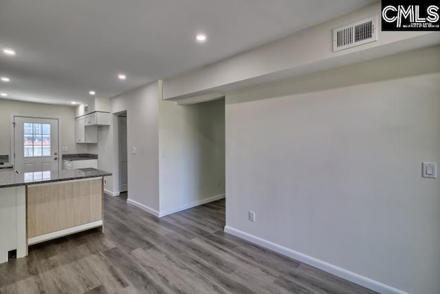 kitchen with dark wood-type flooring, light brown cabinets, and white cabinets