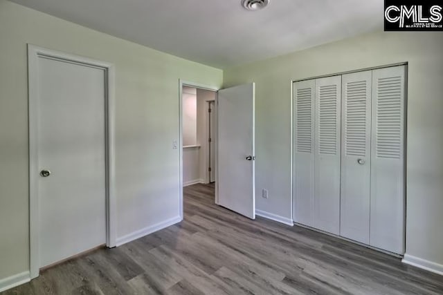 unfurnished bedroom featuring light hardwood / wood-style flooring and a closet