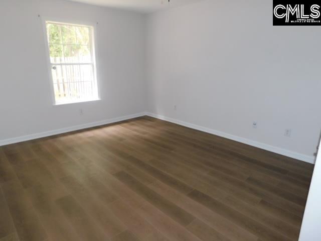 spare room featuring ceiling fan and dark hardwood / wood-style flooring