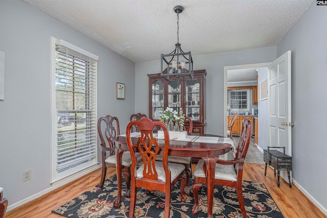 dining area featuring light hardwood / wood-style floors and a textured ceiling