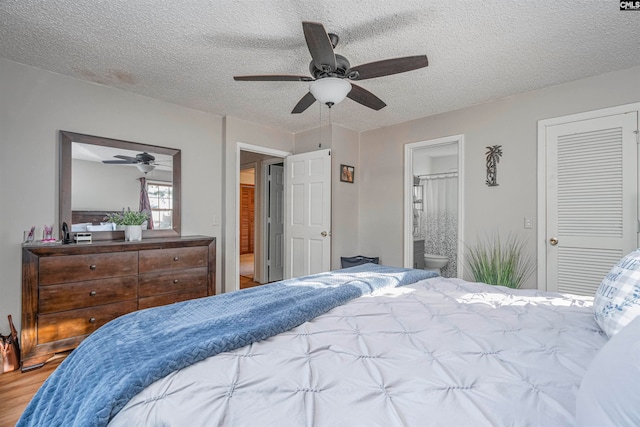 bedroom with ensuite bathroom, ceiling fan, a textured ceiling, and hardwood / wood-style flooring