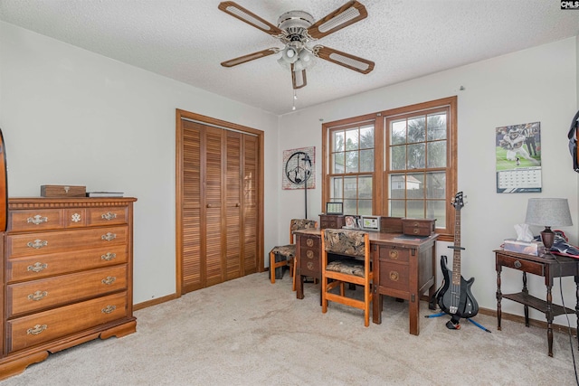 office area featuring ceiling fan, light colored carpet, and a textured ceiling