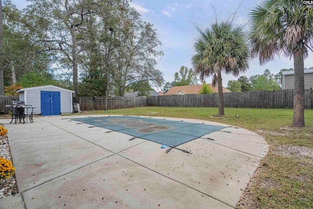 view of pool with a yard, a patio, and a storage unit