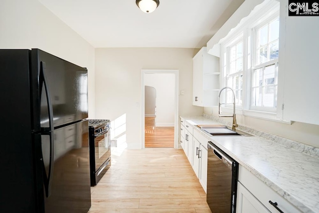 kitchen featuring sink, black appliances, light hardwood / wood-style flooring, and white cabinets