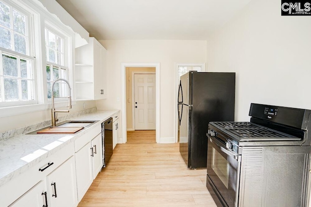 kitchen with white cabinetry, light hardwood / wood-style floors, black appliances, and sink