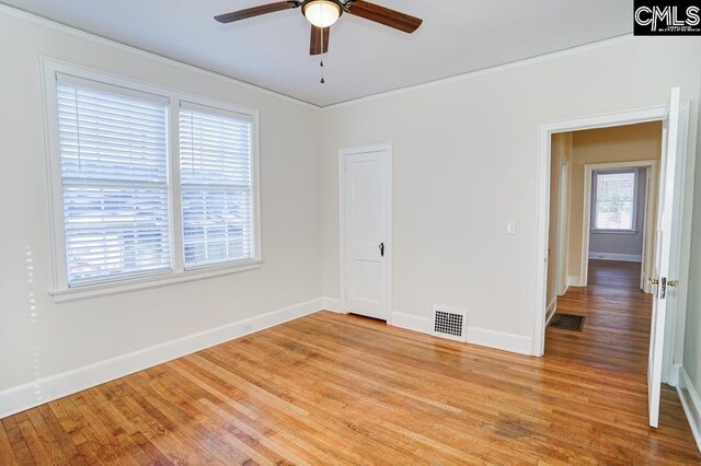 unfurnished room with light hardwood / wood-style floors, ornamental molding, and ceiling fan