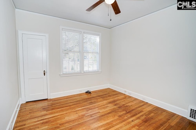 empty room featuring ceiling fan, ornamental molding, and light wood-type flooring