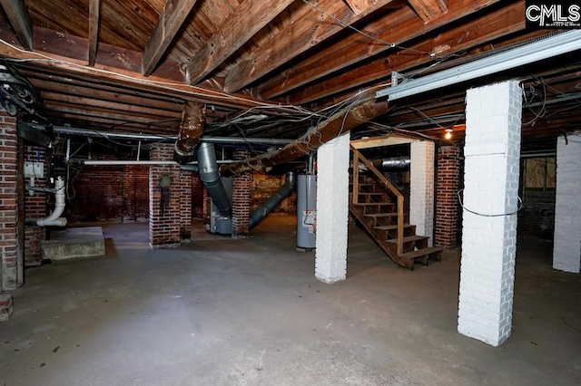 basement featuring brick wall and gas water heater